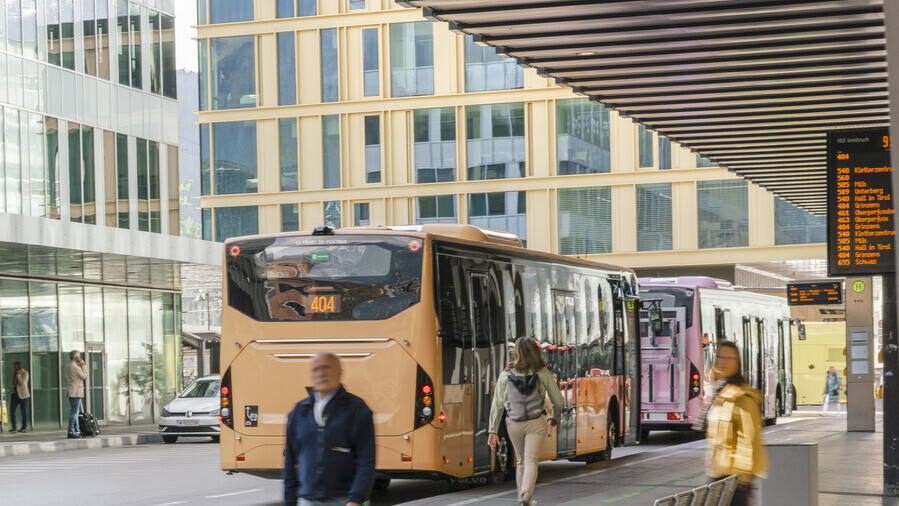 Bus und Personen am Busbahnhof in Innsbruck.