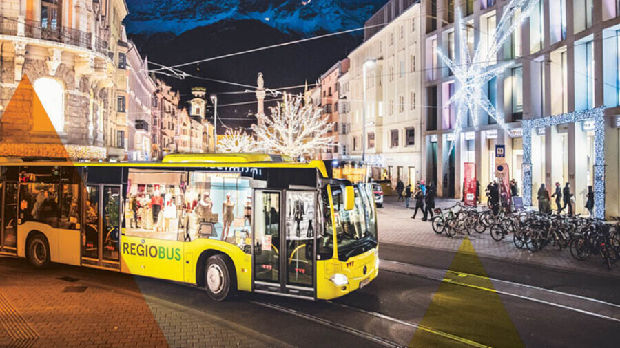 Ein VVT-Regiobus f&auml;hrt Am Abend durch die weihnachtlich beleuchtete Maria-Theresien-Stra&szlig;e in Innsbruck mit Blick auf die Annas&auml;ule und die Nordkette.