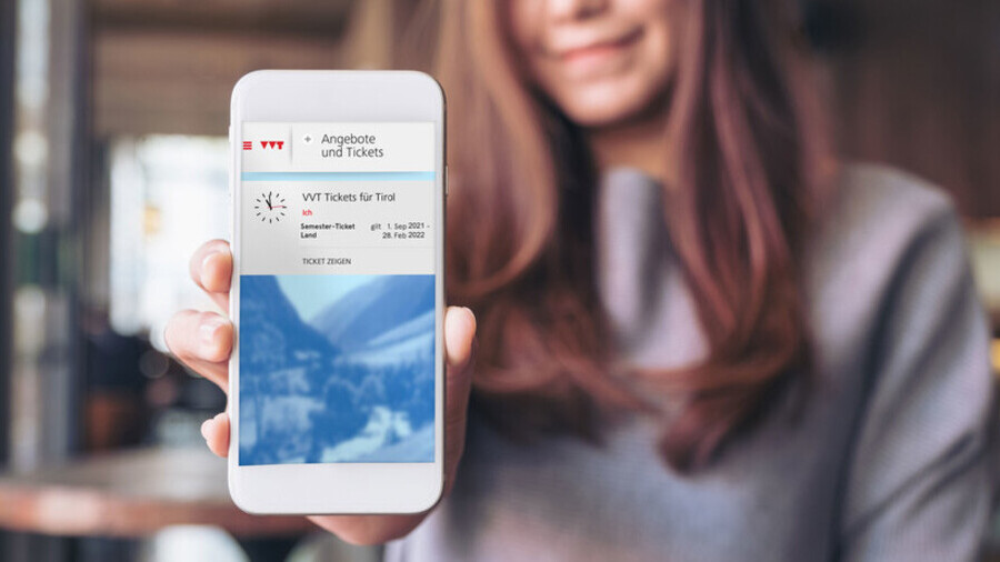 Das Semester-Ticket Land in der VVT Tickets App wird im weißen Smartphone einer langhaarigen Frau angezeigt.